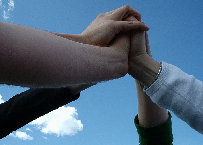 picture of four hands clasped together